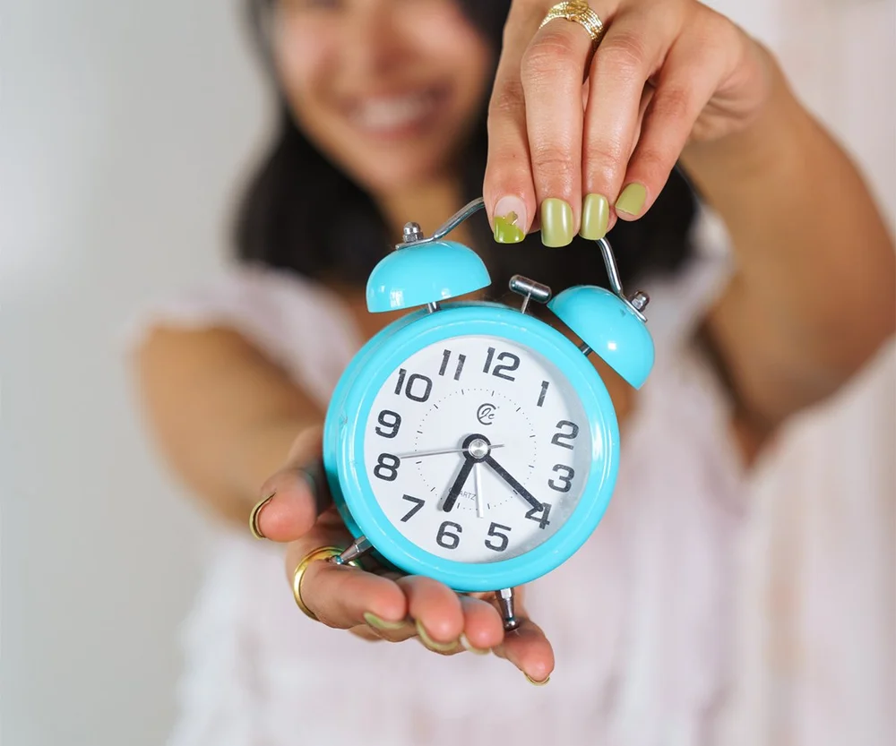 Megan holding a blue clock