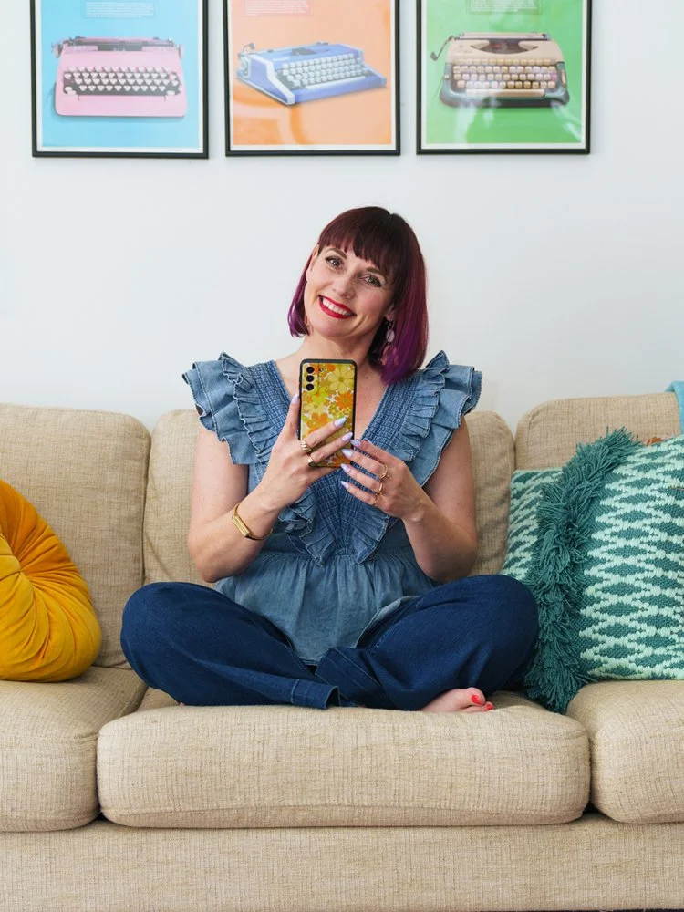 Taryn sitting on a couch holding a phone